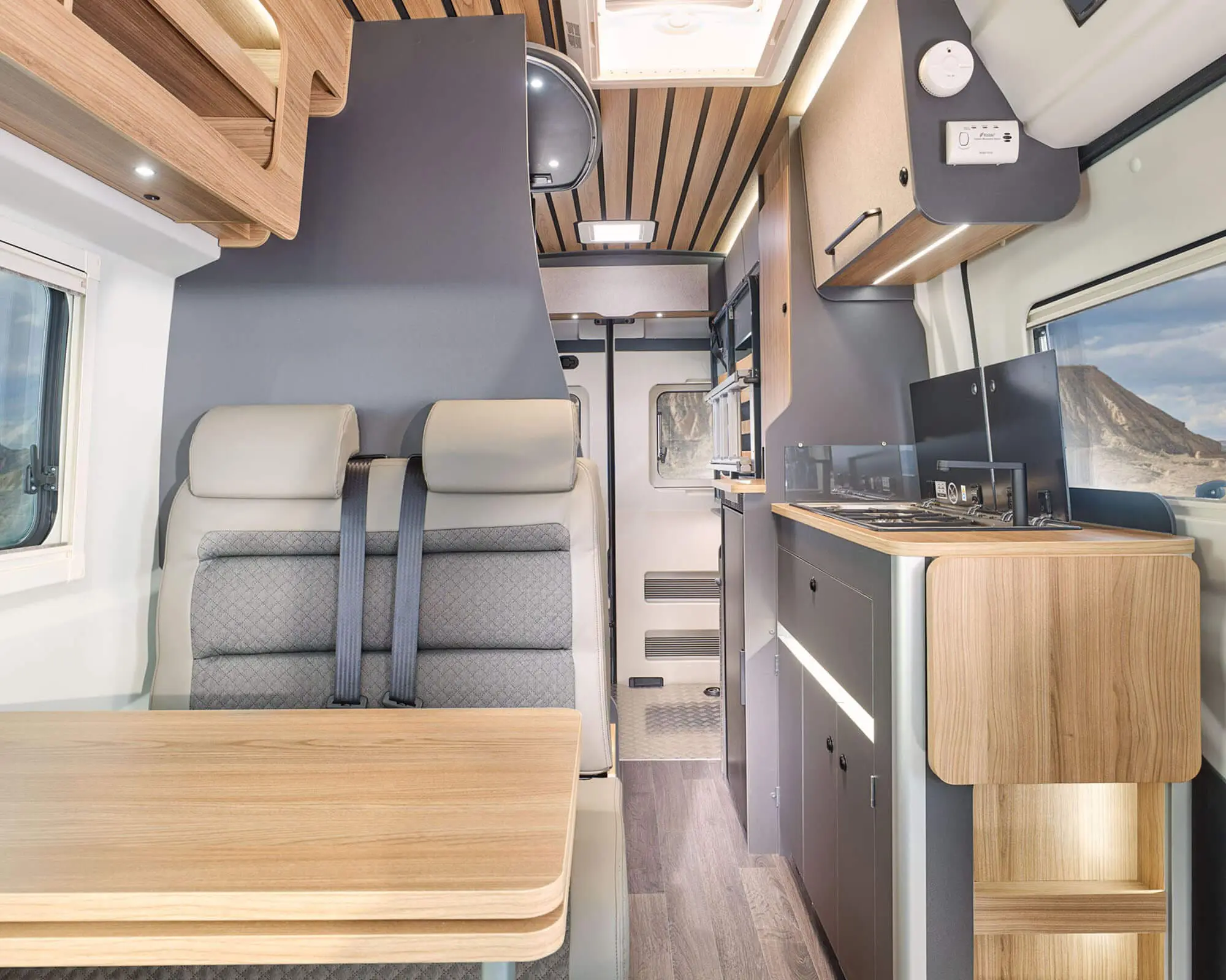 Modern and spacious interior view of a Bailey motorhome featuring comfortable seating and a kitchen area.