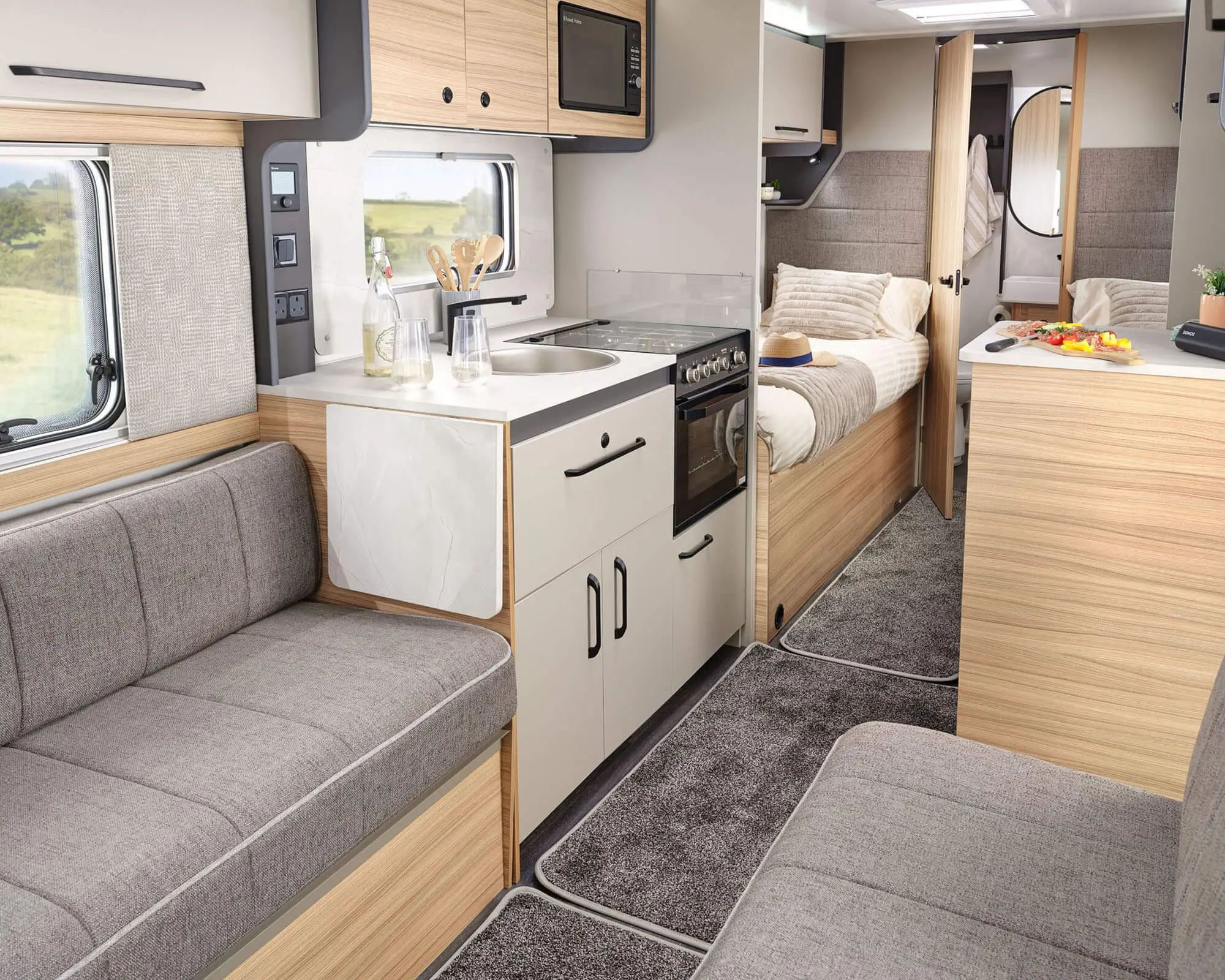 Spacious interior of a Bailey caravan with a kitchen, lounge area, and sleeping space