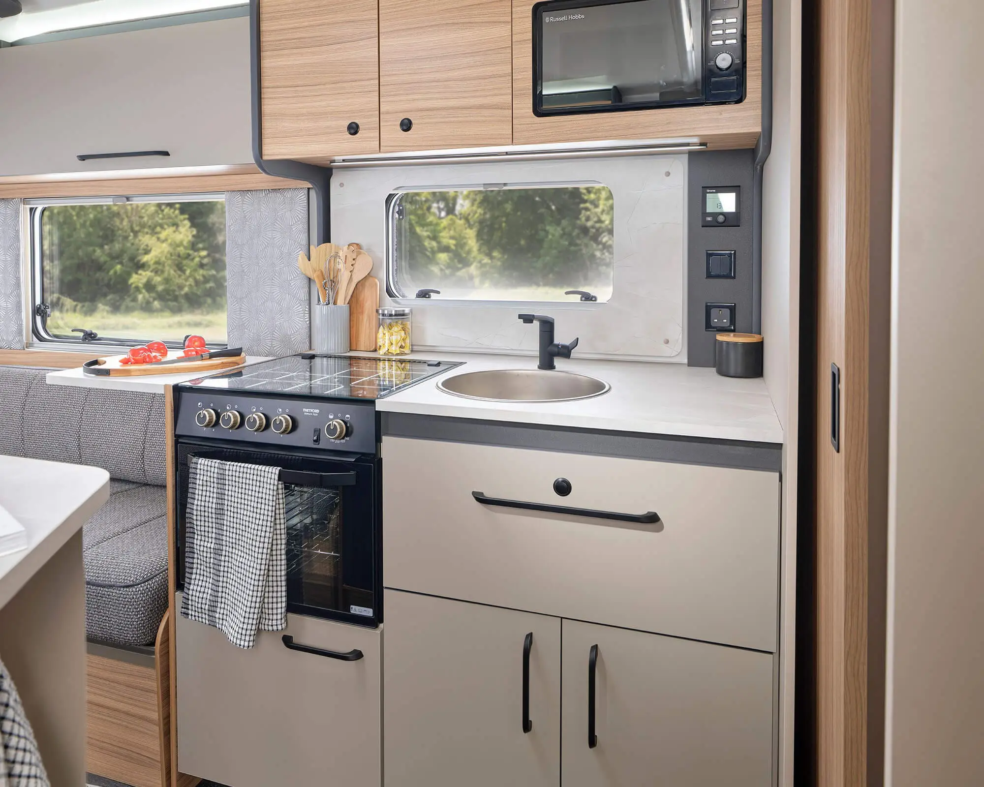 Modern kitchen with oven, sink, and storage in a Bailey caravan interior setting.