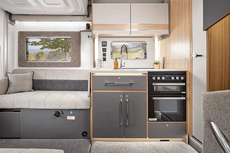 Interior of a Bailey Motorhome with Kitchen and Seating Area Modern and stylish interior of a Bailey motorhome showcasing a kitchen area with oven and spacious seating.