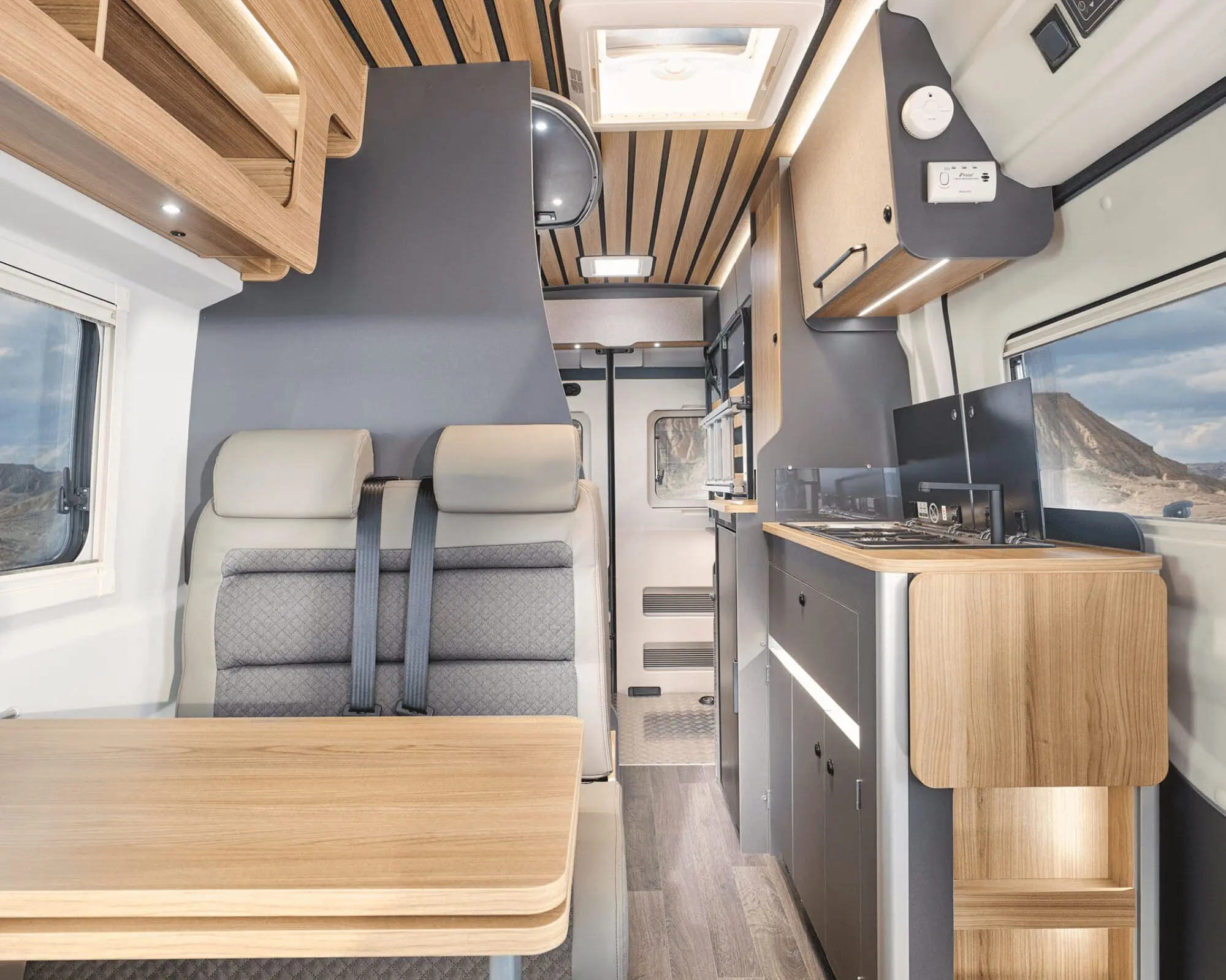 Interior view of a Bailey campervan featuring a dining area, kitchen, and seating arrangement.