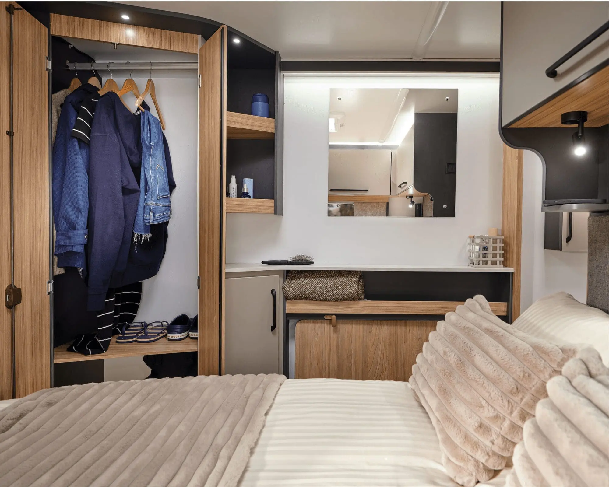 Stylish Interior of a Bailey Motorhome with Cozy Bedroom and Storage Interior view of a Bailey motorhome featuring a cozy bedroom, storage options, and a mirror.