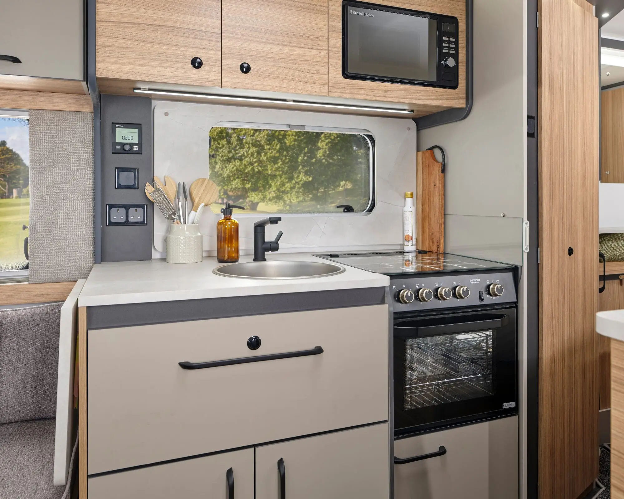 Modern Caravan Kitchen Interior Stylish kitchen area in a Bailey caravan featuring countertop, sink, oven, and microwave.