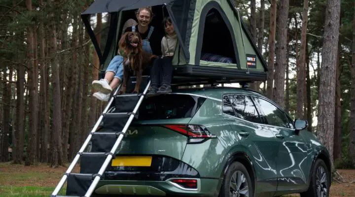 A family enjoying a camping experience with a TentBox on a vehicle, set in a forest environment.