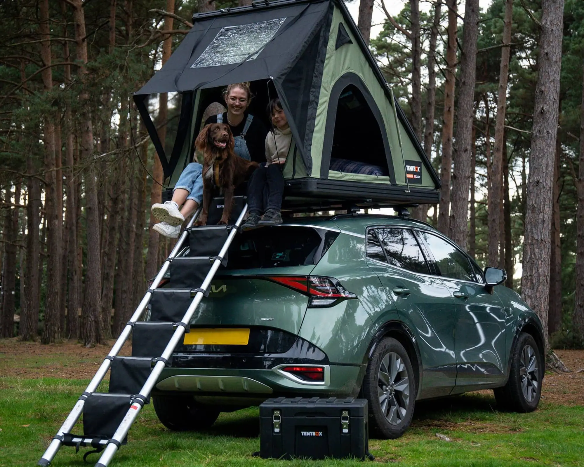 A family enjoying a camping experience with a TentBox on a vehicle, set in a forest environment.