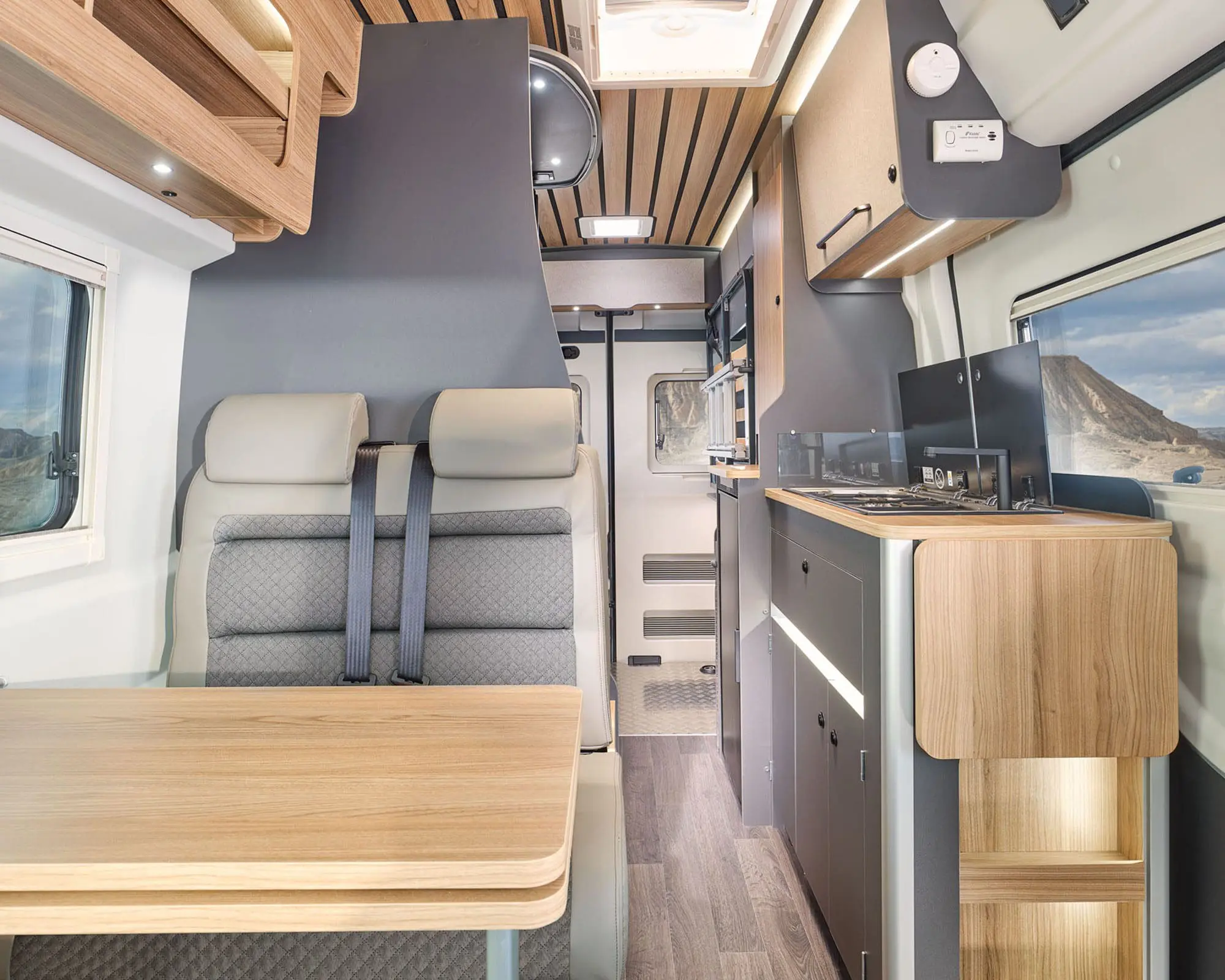 Spacious and sleek interior design of a Bailey Campervan featuring a dining area and kitchen space