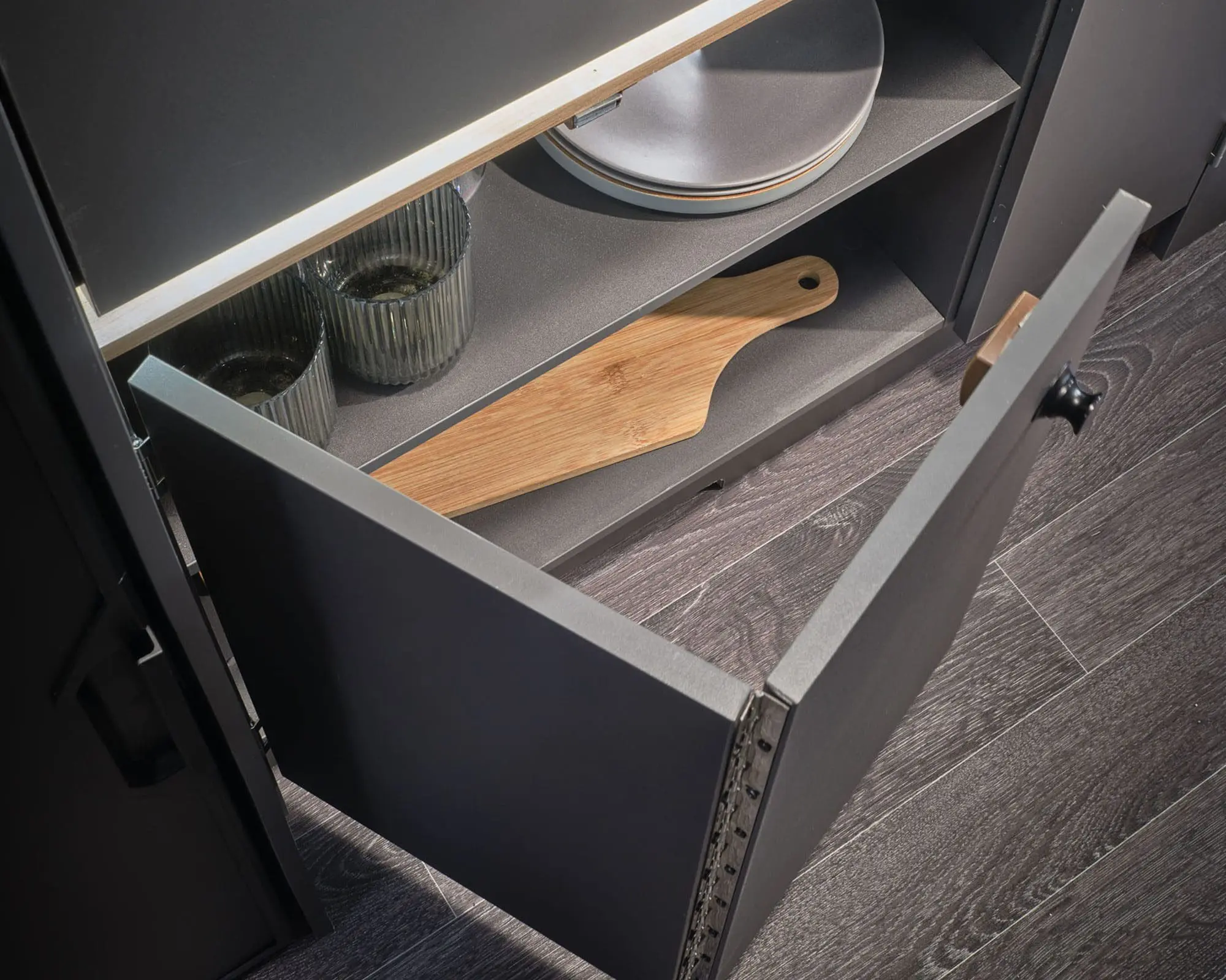 Open cabinet featuring kitchenware items in a Bailey caravan or Campervan.