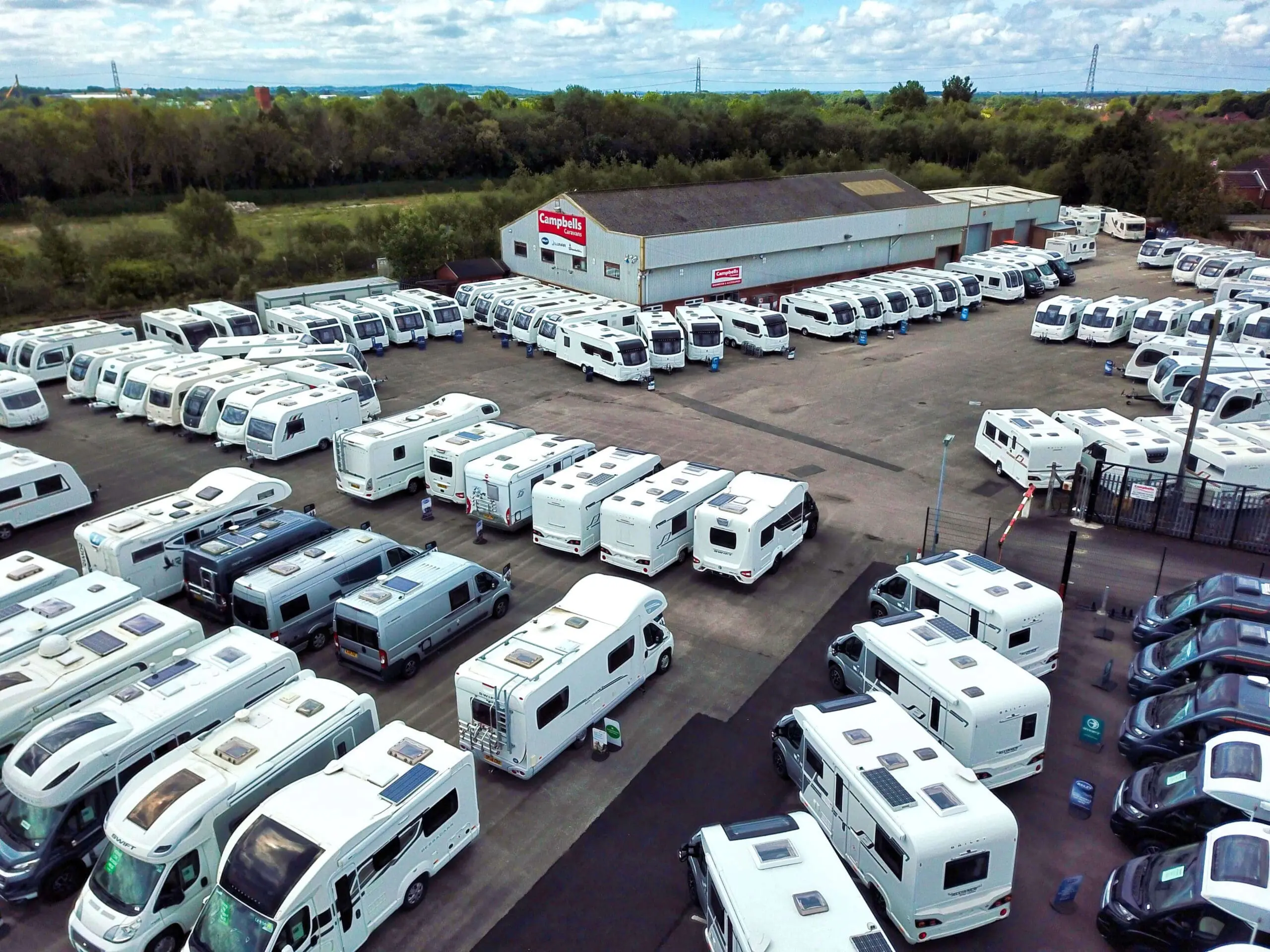 Overview of a large inventory of Bailey caravans and motorhomes in a dealership lot
