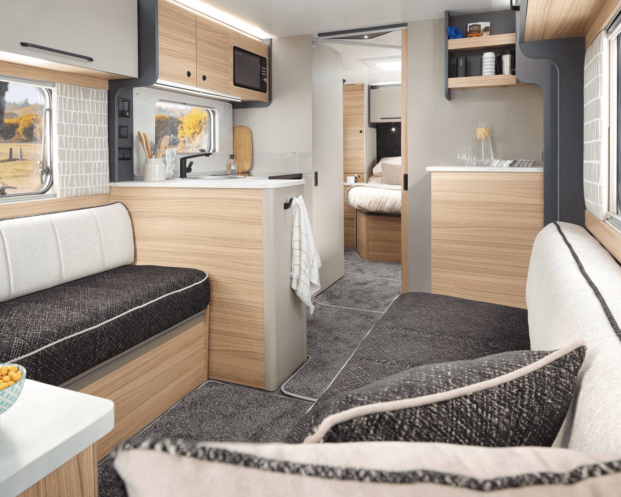Spacious and stylish interior design of a Bailey caravan with comfortable seating and well-equipped kitchen area.