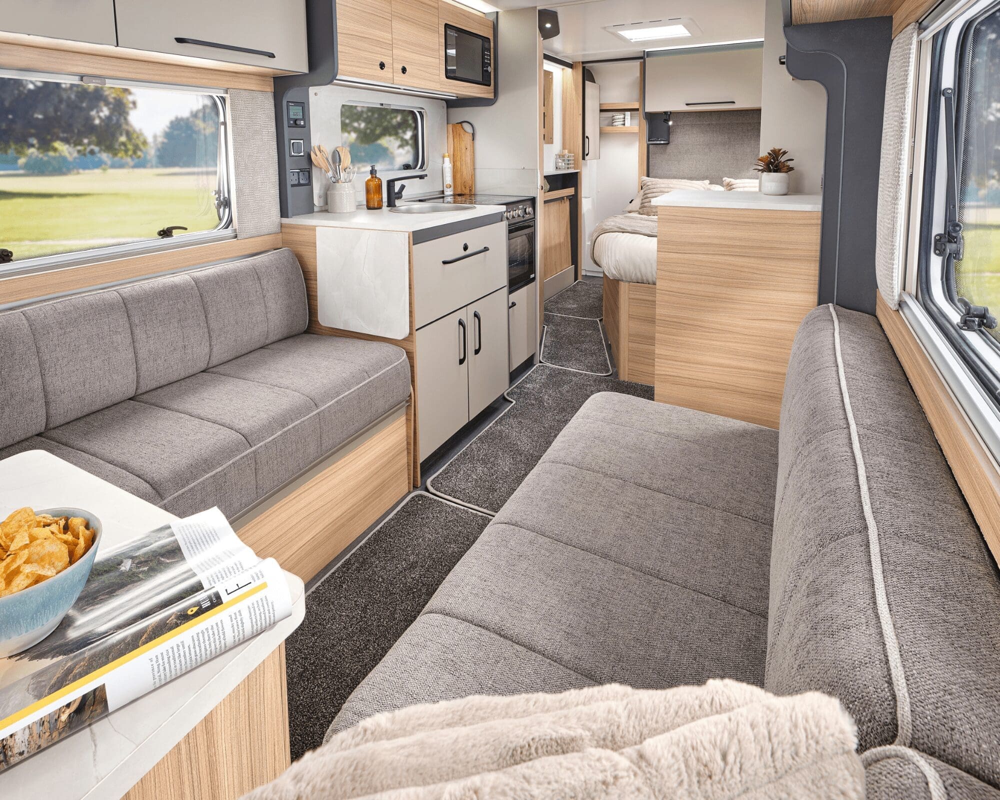 Spacious and stylish interior of a Bailey caravan, featuring comfortable seating and kitchen amenities.