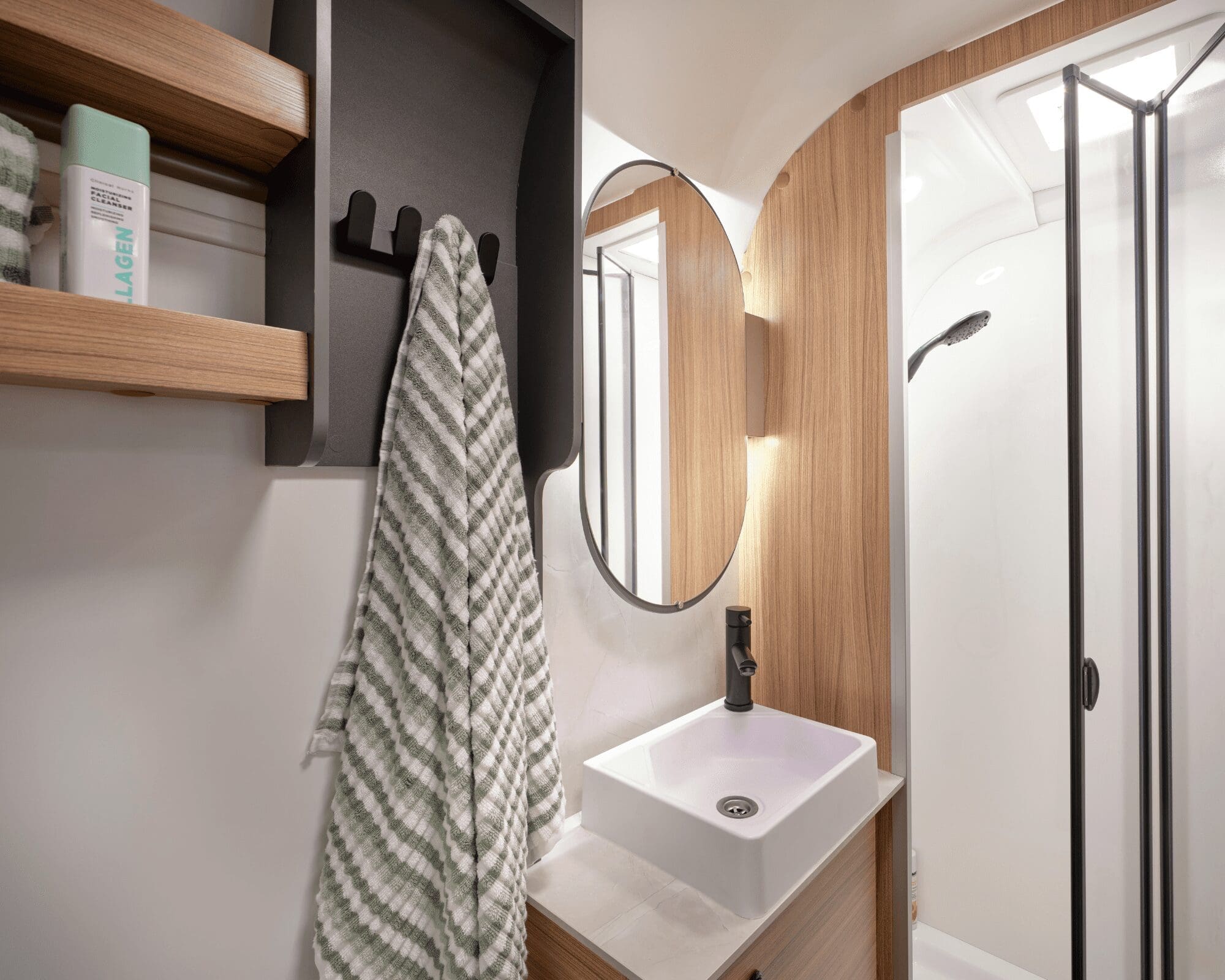 Stylish bathroom interior featuring a shower, sink, and wooden accents in a caravan