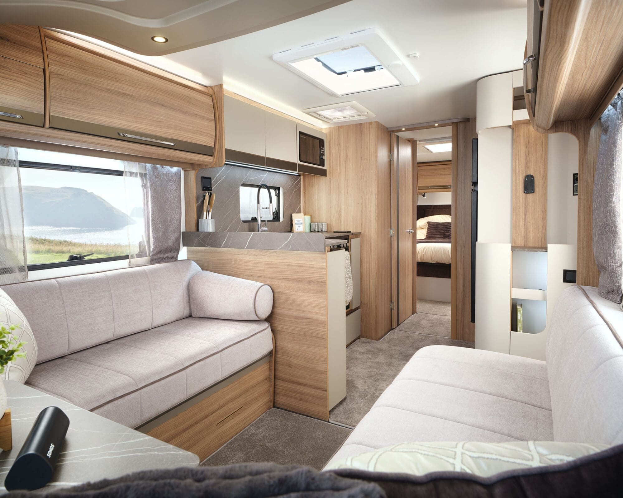 Spacious and stylish interior of a Bailey caravan featuring seating and kitchen area