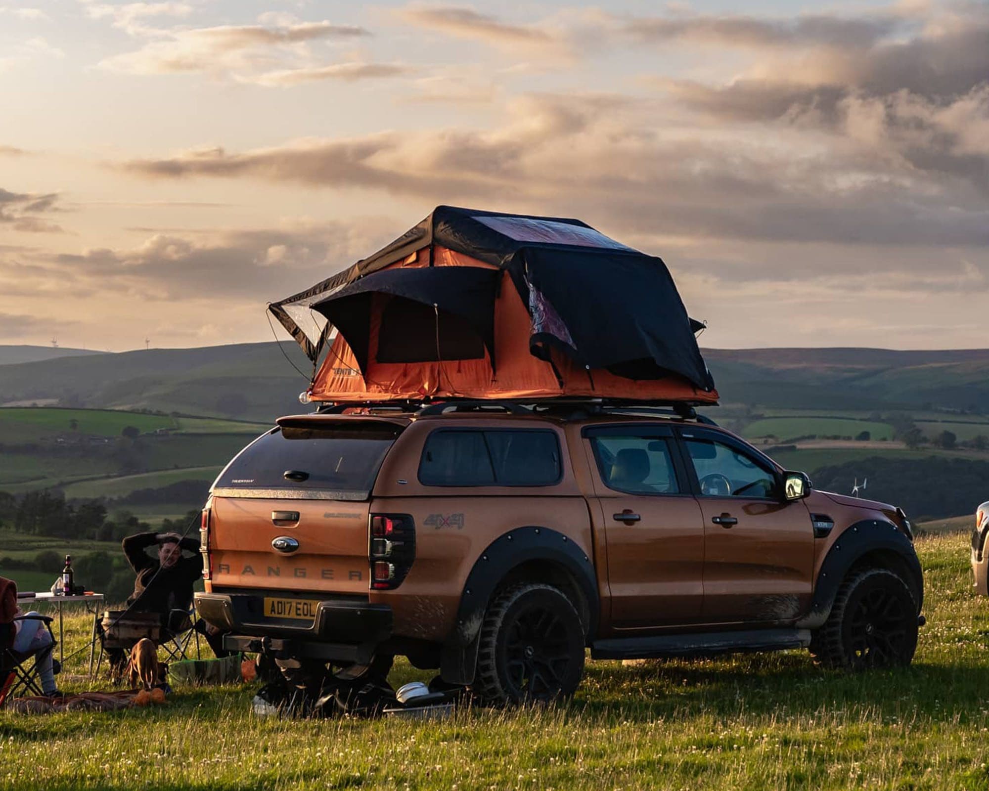 A vehicle equipped with a TentBox at a scenic campsite during sunset, showcasing outdoor adventure possibilities.