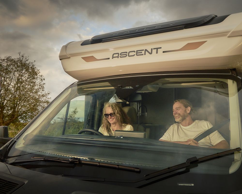Couple driving a Bailey Ascent motorhome through the countryside
